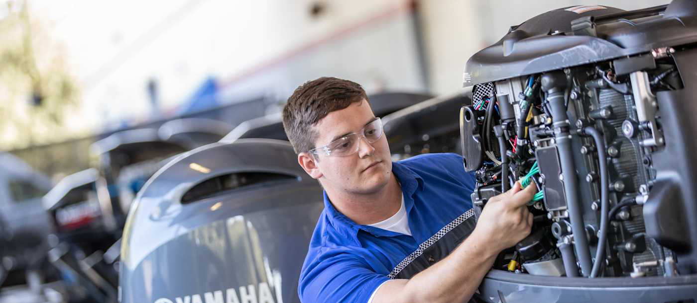 Marine technician inspecting a Yamaha outboard engine